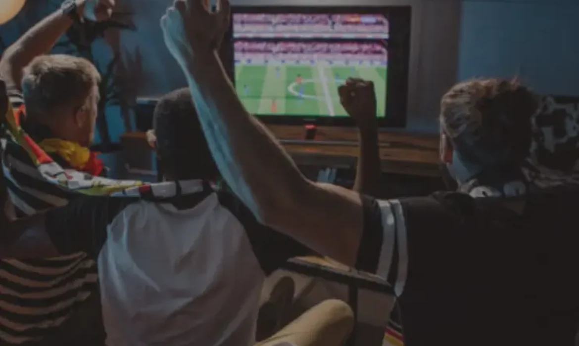 Amis regardant un match de sport en streaming avec Orca Pro Max IPTV – Stabilité et qualité HD/4K pour une expérience immersive.